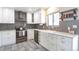 Modern kitchen features stainless steel appliances, white cabinetry, granite countertops, and farmhouse sink at 2055 Quail Dr, Lakewood, CO 80215