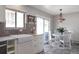 Bright eat-in kitchen with white cabinets, stainless appliances, and dining area with a stylish chandelier at 2055 Quail Dr, Lakewood, CO 80215
