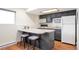 Cozy kitchenette featuring modern appliances, an island with barstool seating at 2055 Quail Dr, Lakewood, CO 80215
