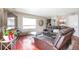 Comfortable living room featuring a leather sectional, hardwood floors, and ample natural light from a large window at 2055 Quail Dr, Lakewood, CO 80215