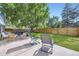 A spacious backyard with lawn, patio seating area, and a privacy fence, perfect for outdoor entertaining at 6995 W 27Th Ave, Wheat Ridge, CO 80033