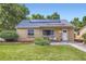Charming brick home featuring solar panels, manicured lawn, and inviting front patio seating area at 6995 W 27Th Ave, Wheat Ridge, CO 80033