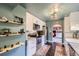 Well-lit kitchen featuring modern appliances, white cabinets, and floating shelves for added storage at 6995 W 27Th Ave, Wheat Ridge, CO 80033