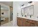 Bright bathroom with a double sink vanity, modern fixtures, and a view into an adjacent bedroom at 169 Yates St, Denver, CO 80219