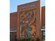 Brick building featuring a large art installation and the 'Cherry Creek' sign above at 512 Cook St, Denver, CO 80206