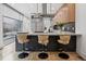 Sleek modern kitchen featuring barstool seating, stainless appliances, and light wood cabinets at 512 Cook St, Denver, CO 80206