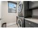 Modern laundry room featuring stacked washer and dryer, complemented by sleek gray cabinetry at 512 Cook St, Denver, CO 80206