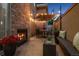 Outdoor patio area with fireplace, dining table, string lights, and potted plants at 512 Cook St, Denver, CO 80206