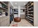 Large walk-in closet with custom built-ins and central ottoman at 512 Cook St, Denver, CO 80206