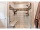 A well-appointed shower is designed with tiled walls and a built-in bench and tasteful shelving at 21302 E Radcliff Pl, Aurora, CO 80015