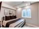 Finished bedroom includes a comfortable bed, dark art, and an egress window at 21302 E Radcliff Pl, Aurora, CO 80015