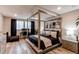 A bedroom boasts a wooden frame bed, wood floors, neutral decor, and ample natural light at 21302 E Radcliff Pl, Aurora, CO 80015
