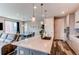 Stylish kitchen island with seating, pendant lights, and open layout to dining area at 21302 E Radcliff Pl, Aurora, CO 80015