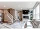 Open-concept living area featuring a fireplace, staircase, and seamless flow to the kitchen at 21302 E Radcliff Pl, Aurora, CO 80015