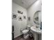 Charming powder room with pedestal sink, oval mirror, and decorative wall art at 17614 Cherokee St, Broomfield, CO 80023