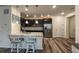 Modern kitchen with black cabinets, granite counters, stainless appliances, and island seating at 17614 Cherokee St, Broomfield, CO 80023