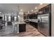 Modern kitchen with island seating flows into living area with stainless appliances at 17614 Cherokee St, Broomfield, CO 80023