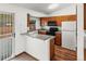 Well-lit kitchen featuring wood cabinets and a peninsula island at 12116 N Fairfax St, Thornton, CO 80241