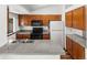 Functional kitchen with wooden cabinets, granite countertops, and white appliances at 12116 N Fairfax St, Thornton, CO 80241