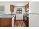 Compact kitchen with wooden cabinets, granite countertops, and modern black appliances at 12116 N Fairfax St, Thornton, CO 80241