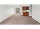 Open living room with neutral carpet and a view into the kitchen area at 12116 N Fairfax St, Thornton, CO 80241