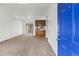 Open living room featuring neutral carpet, built-in shelving, and a sliding glass door to the backyard at 12116 N Fairfax St, Thornton, CO 80241