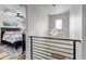 Hallway view leading into bedroom with black frame bed, and a decorative chandelier and window at 21658 E Tallkid Ave, Parker, CO 80138