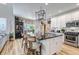 Modern kitchen featuring a large island with seating, white cabinetry, and stainless steel appliances at 21658 E Tallkid Ave, Parker, CO 80138