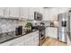Well-lit kitchen features stainless steel appliances, granite countertops, and lovely backsplash at 21658 E Tallkid Ave, Parker, CO 80138