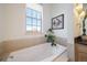 Relaxing bathroom with a soaking tub and large window at 7777 E 1St Pl # 110, Denver, CO 80230