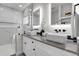 Double sink vanity with sleek hardware, modern mirrors, and elegant marble-look shower at 2827 Bellaire St, Denver, CO 80207