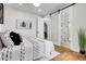 Bright bedroom featuring wood floors, barn door entry to bathroom and minimalist decor at 2827 Bellaire St, Denver, CO 80207