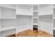 Organized walk-in closet with custom white shelving and wood flooring at 2827 Bellaire St, Denver, CO 80207