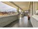 Spacious covered front porch featuring gray brick accents, tiled flooring, and wrought iron railing at 2827 Bellaire St, Denver, CO 80207