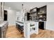 Modern kitchen with dark cabinets, a center island with seating, and stylish open shelving at 2827 Bellaire St, Denver, CO 80207