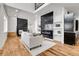 Bright, open living area featuring a modern fireplace, and a seamless flow to the dining and kitchen spaces at 2827 Bellaire St, Denver, CO 80207