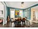 Stylish dining room featuring dark teal walls, hardwood floors, two windows, art and white shelving at 1433 Olive St, Denver, CO 80220