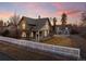 Beautiful two-story home with a detached two-car garage, complemented by a white picket fence and a manicured lawn at 1433 Olive St, Denver, CO 80220