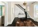 Elegant foyer featuring dark wood floors, a decorative rug, a staircase, and stylish lighting at 1433 Olive St, Denver, CO 80220