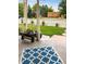 Cozy front porch with a blue and white patterned rug, greenery, and white picket fence at 1433 Olive St, Denver, CO 80220