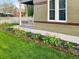 Charming home exterior featuring a lush lawn and vibrant flower beds along the walkway at 1433 Olive St, Denver, CO 80220