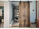 Convenient laundry room features a stackable washer and dryer hidden behind a rustic barn door for added privacy at 1433 Olive St, Denver, CO 80220
