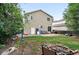 Lush backyard with mature trees, patio and fire pit, perfect for enjoying outdoor living at 1419 Swan Ave, Brighton, CO 80601