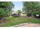 Large backyard with a trampoline, storage shed, and mature trees, offering privacy and space at 1419 Swan Ave, Brighton, CO 80601