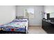Bedroom featuring a cozy bed with sports-themed bedding and a dark wood dresser under a window at 1419 Swan Ave, Brighton, CO 80601