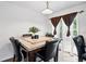 Dining area showcasing a stylish table with seating, tile flooring, and ample natural light from the window at 1419 Swan Ave, Brighton, CO 80601