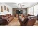 Cozy living room featuring comfortable leather seating, a ceiling fan, and a modern entertainment center at 1419 Swan Ave, Brighton, CO 80601