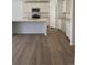 Bright kitchen featuring white cabinetry, stainless steel appliances, granite countertops, and hardwood floors at 21966 E 39Th Pl, Aurora, CO 80019
