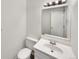 Cozy bathroom featuring a white sink, vanity, toilet, and a well-lit mirror at 9976 Appletree Pl, Thornton, CO 80260