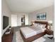 A staged bedroom with a large bed, lamps, and a painting on the wall at 9976 Appletree Pl, Thornton, CO 80260